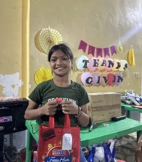 A child holding gifts at the Thanksgiving celebration